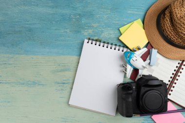 Düz konsept seyahat aksesuarları tatil gezisi ve uzun yaz hafta sonu planlama mavi ahşap masa üzerinde metin arkaplanı için boş alan.