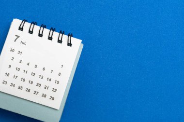 mavi masa arkaplanındaki takvimi kapat, iş toplantısı ya da seyahat planlama konsepti için planlama