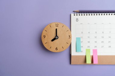 Mor masa arkaplanındaki takvimin kapatılması, iş toplantısı veya seyahat planlama konsepti için planlama