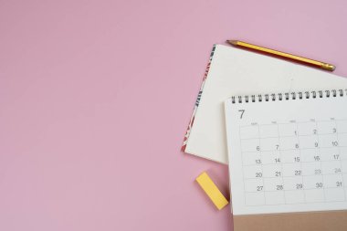 Pembe masa arkaplanındaki takvimi kapat, iş toplantısı ya da seyahat planlama konseptini planla