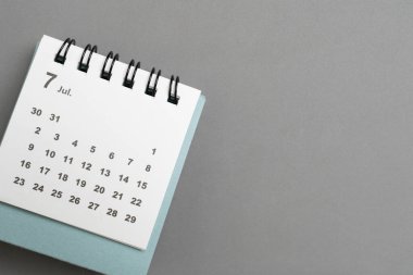 Gri masa arkaplanındaki takvimin kapatılması, iş toplantısı veya seyahat planlama konsepti için planlama