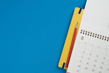 mavi masa arkaplanındaki takvimi kapat, iş toplantısı ya da seyahat planlama konsepti için planlama