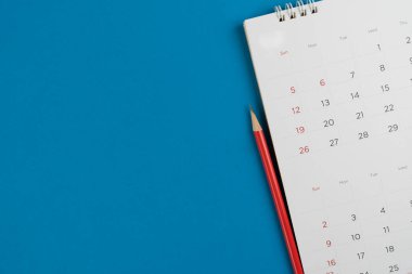 mavi masa arkaplanındaki takvim ve kalemi kapat, iş toplantısı ya da seyahat planlama konseptini planla