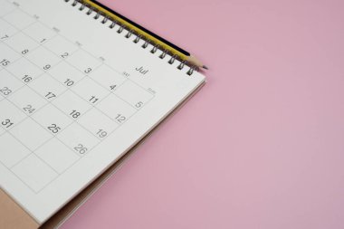 Pembe masa arkaplanındaki takvim ve kalemi kapat, iş toplantısı ya da seyahat planlama konseptini planla