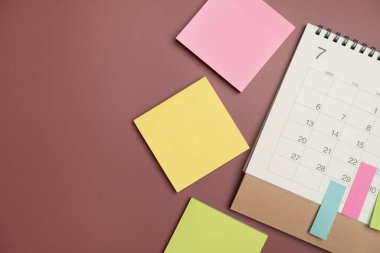 Koyu kırmızı masa arkaplanındaki takvimi kapat, iş toplantısı ya da seyahat planlama konsepti için plan yap