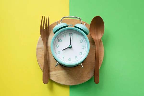 Food alarm clock spoon and fork, Healthy food breakfast concept on colorful background