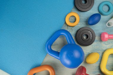Spor ekipmanlarını mavi yoga minderi arka planında kapatıyoruz. Sağlıklı ve egzersiz konsepti.