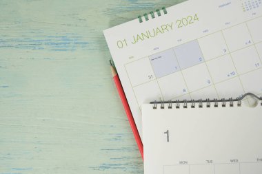 Takvimin mavi masa arkaplanına kapatılması, iş toplantısı ya da seyahat planlama Ocak ayı konsepti