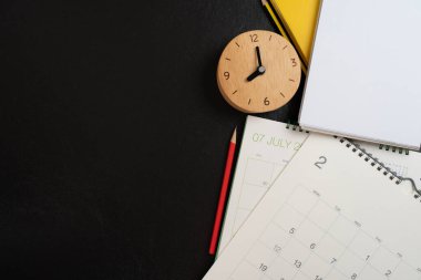Takvimi siyah masa arka planında kapat, iş toplantısı veya seyahat planlama konsepti için planlama