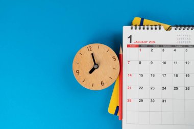 Takvimi ve saati mavi masa arkaplanına kapat, iş toplantısı ya da seyahat planlama konseptini planla