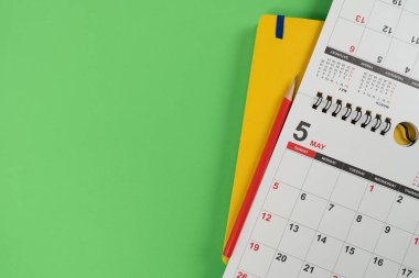 Takvimin yeşil masa arka planında kapatılması, iş toplantısı veya seyahat planlama konsepti için planlama