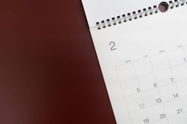 Kırmızı masa arkaplanındaki takvimin kapatılması, iş toplantısı veya seyahat planlama konsepti için planlama