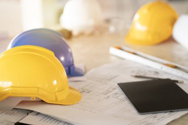 Ofiste miğfer ve bulanık plan geçmişi olan mühendis ya da mimar masası, proje fikirleri kavramı.