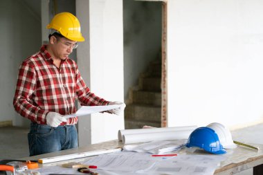 Bir bina inşaatında yakışıklı genç Asyalı mimar veya mühendis..