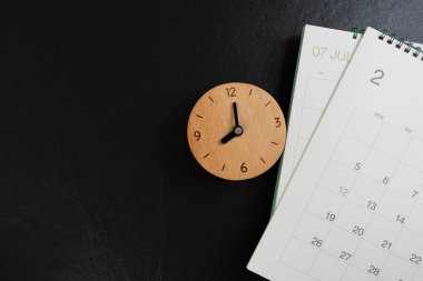 Takvimi siyah masa arka planında kapat, iş toplantısı veya seyahat planlama konsepti için planlama