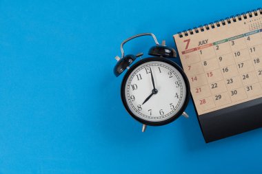 mavi masa arkaplanındaki takvim ve alarmın kapatılması, iş toplantısı ya da seyahat planlama konsepti