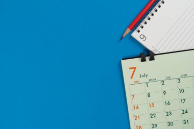 mavi masa arkaplanındaki takvimi kapat, iş toplantısı ya da seyahat planlama konsepti için planlama