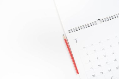 Beyaz masa arkaplanındaki takvim ve kalemi kapat, iş toplantısı ya da seyahat planlama konsepti için planlama