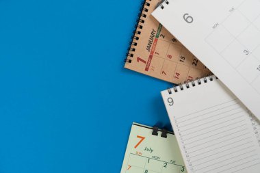 mavi masa arkaplanındaki takvimi kapat, iş toplantısı ya da seyahat planlama konsepti için planlama