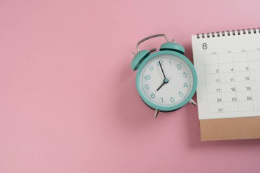 Alarm saatini ve takvimi pembe masa arkaplanına kapat, iş toplantısı ya da seyahat planlama