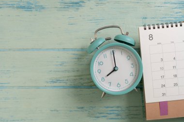 mavi masa arkaplanındaki takvim ve alarmın kapatılması, iş toplantısı ya da seyahat planlama konsepti