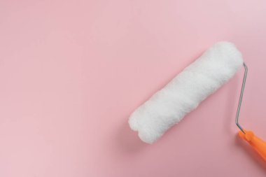 Pembe arka plan evindeki fırça boyası silindirini kapat.