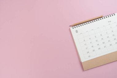 Pembe masa arkaplanındaki takvimi kapat, iş toplantısı ya da seyahat planlama konseptini planla