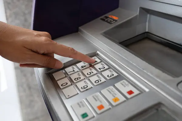 stock image Close up of woman hand entering PIN code into an ATM bank machine.