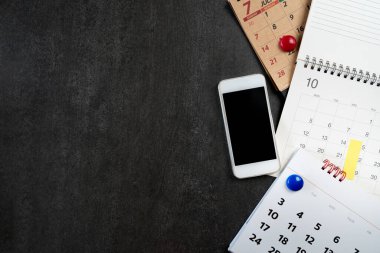 Takvim ve cep telefonlarını siyah masa arkaplanına kapat, iş toplantısı ya da seyahat planlama
