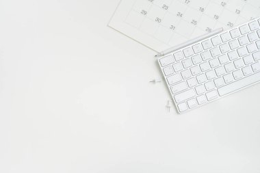 Beyaz masa arkaplanındaki takvim ve klavyeyi kapat, iş toplantısı ya da seyahat planlama konseptini planla