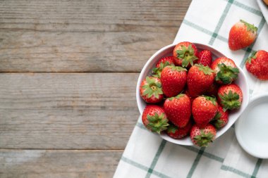 Tahta masadaki kasede taze çilekler.