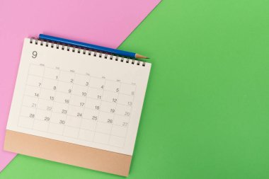 Renkli masa arkaplanındaki takvim ve kalemi kapat, iş toplantısı ya da seyahat planlama konseptini planla