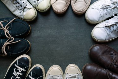 Siyah zemin üzerinde çeşitli tarzlarda ayakkabılar üst görünüm, yaşam tarzları konsepti.