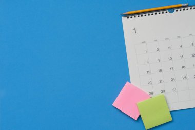 mavi masa arkaplanındaki takvimi kapat, iş toplantısı ya da seyahat planlama konsepti için planlama