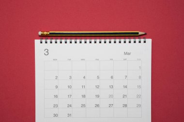 Kırmızı masa arkaplanındaki takvim ve kalemi kapat, iş toplantısı ya da seyahat planlama konseptini planla