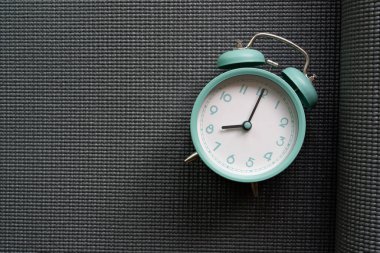 Gri yoga minder dokusu ve arka planı olan çalar saati kapat, spor konsepti.