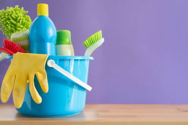 Masanın üzerinde mor arka planı, ev servisi ya da temizlik konsepti olan ev temizleme plastik ürünü