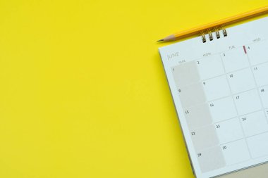 sarı masa arkaplanındaki takvim ve kalemi kapat, iş toplantısı ya da seyahat planlama konseptini planla