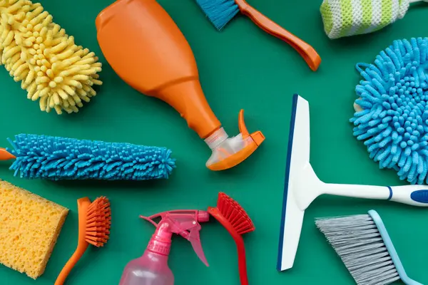 House cleaning plastic product on green table background, home service or housekeeping concept