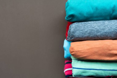 Kahverengi masa arkası, seyahat ve yaşam tarzı kavramına sarılmış renkli t-shirt giysilerini kapat