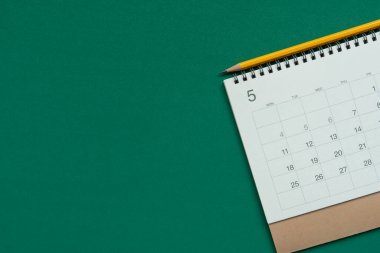 Yeşil masa arkaplanındaki takvim ve kalemi kapat, iş toplantısı ya da seyahat planlama konseptini planla