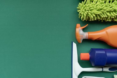 House cleaning plastic product on green table background, home service or housekeeping concept