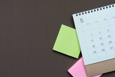 kahverengi masa arkaplanındaki takvimin kapatılması, iş toplantısı ya da seyahat planlama konsepti