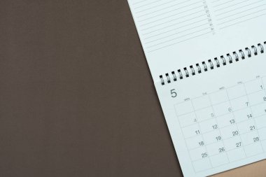 kahverengi masa arkaplanındaki takvimin kapatılması, iş toplantısı ya da seyahat planlama konsepti