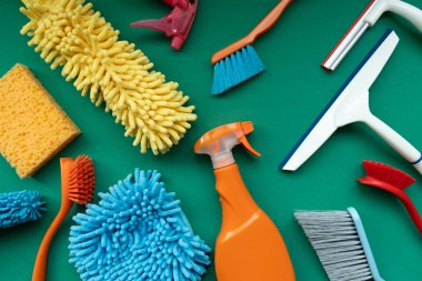 House cleaning plastic product on green table background, home service or housekeeping concept