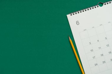 Takvimin yeşil masa arka planında kapatılması, iş toplantısı veya seyahat planlama konsepti için planlama