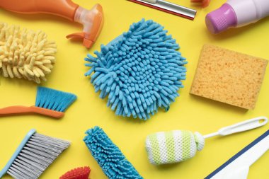 Sarı masa arkaplanındaki ev temizleme plastik ürünü, ev servisi veya temizlik konsepti