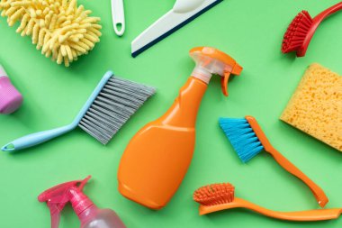House cleaning plastic product on green table background, home service or housekeeping concept