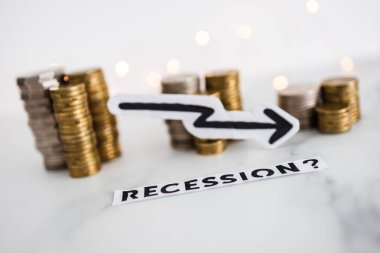 Ekonomik büyümeyi temsil eden ve salgından sonra ekonomik sorunlar kavramını temsil eden bozuk para yığınlarının önünde okun düştüğü durgunluk metni