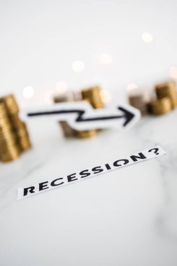 Ekonomik büyümeyi temsil eden ve salgından sonra ekonomik sorunlar kavramını temsil eden bozuk para yığınlarının önünde okun düştüğü durgunluk metni